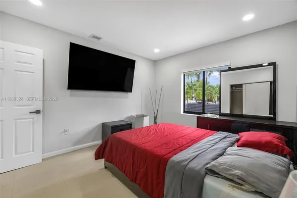 a bedroom with a large bed and a flat screen tv