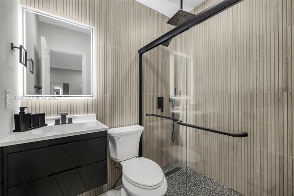 a bathroom with a sink a toilet and shower