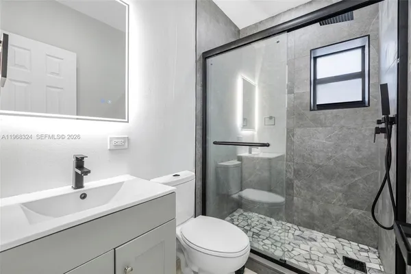 a bathroom with a sink a toilet and shower