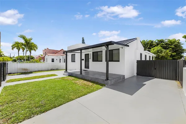 a front view of a house with a yard and palm tree