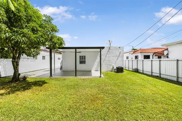 a view of a house with backyard and tree