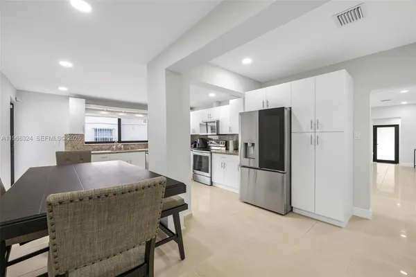 a kitchen with refrigerator and kitchen island
