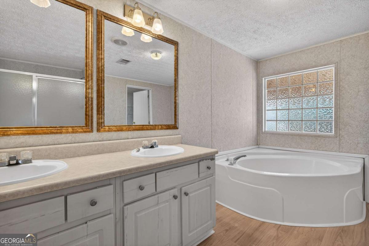 4156 Smiley Road Ludowici, GA 31316 - Photo 14 of 32 a bathroom with a bathtub a sink and a window