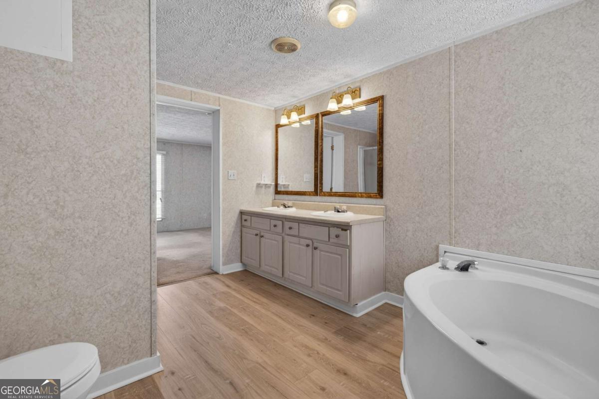 4156 Smiley Road Ludowici, GA 31316 - Photo 15 of 32 a bathroom with a sink a toilet and mirror