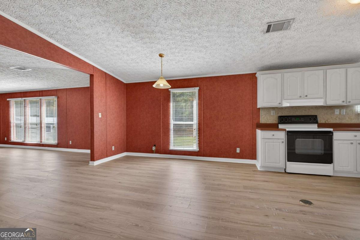 4156 Smiley Road Ludowici, GA 31316 - Photo 16 of 32 a view of an empty room with window and wooden floor