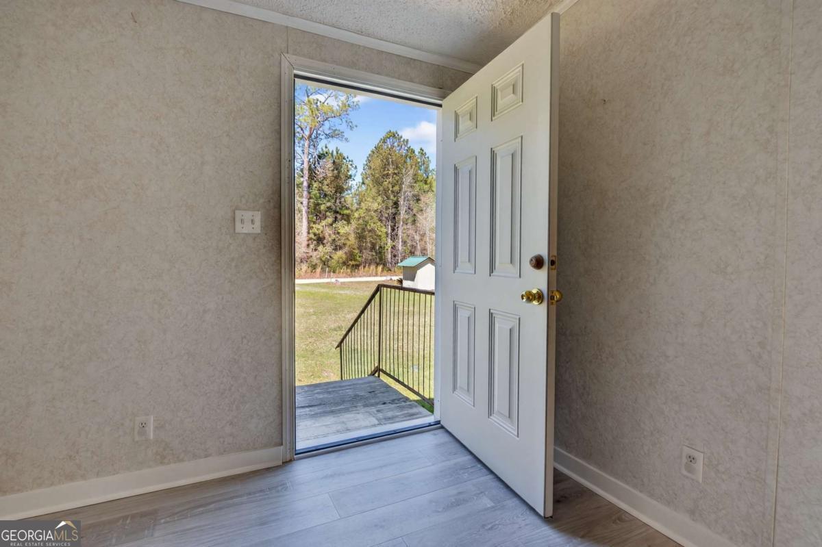 4156 Smiley Road Ludowici, GA 31316 - Photo 2 of 32 a view of a hallway with wooden floor and windows