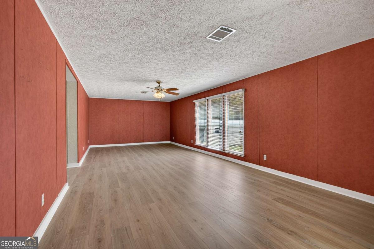 4156 Smiley Road Ludowici, GA 31316 - Photo 22 of 32 an empty room with wooden floor and windows