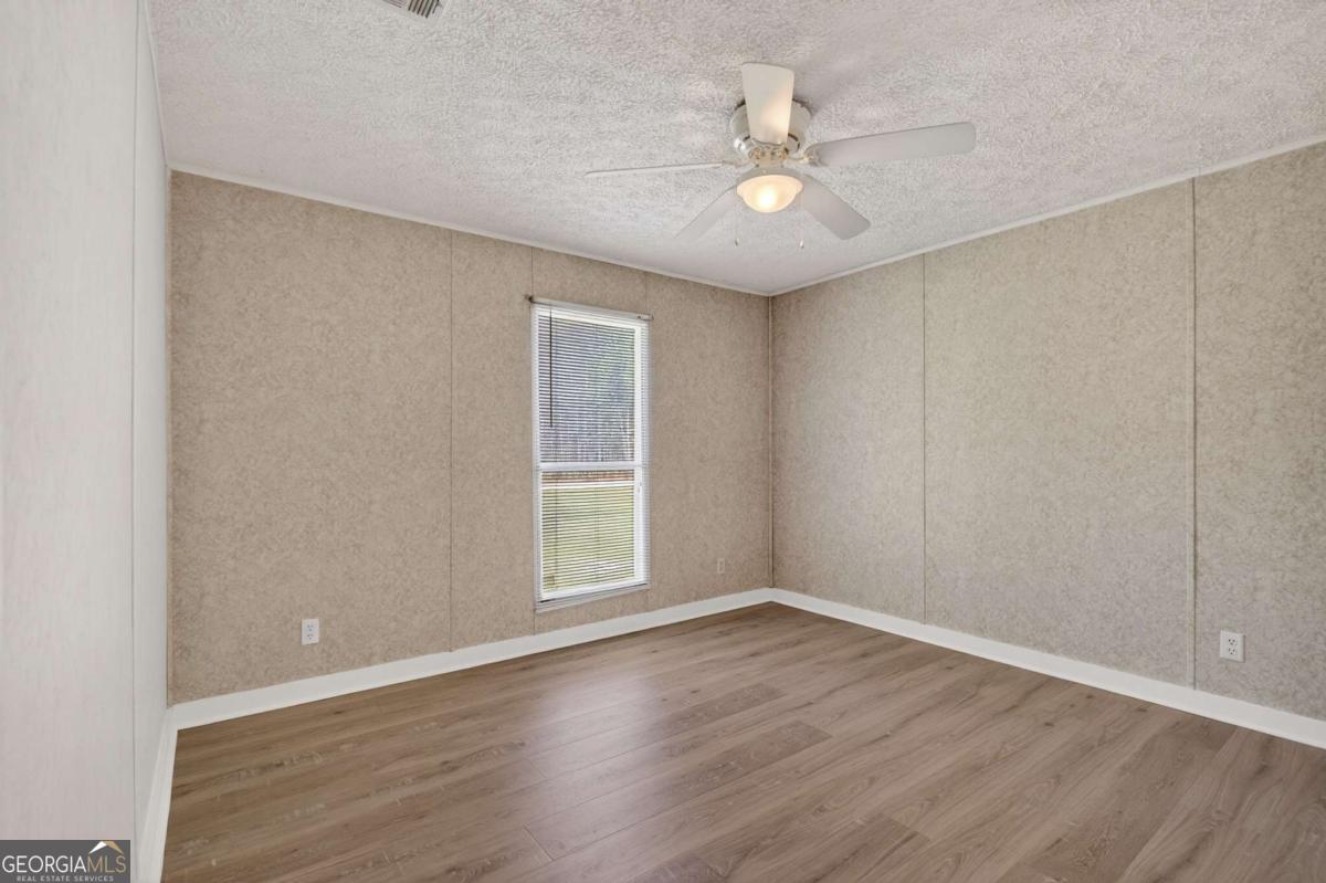4156 Smiley Road Ludowici, GA 31316 - Photo 25 of 32 wooden floor in an empty room with a window