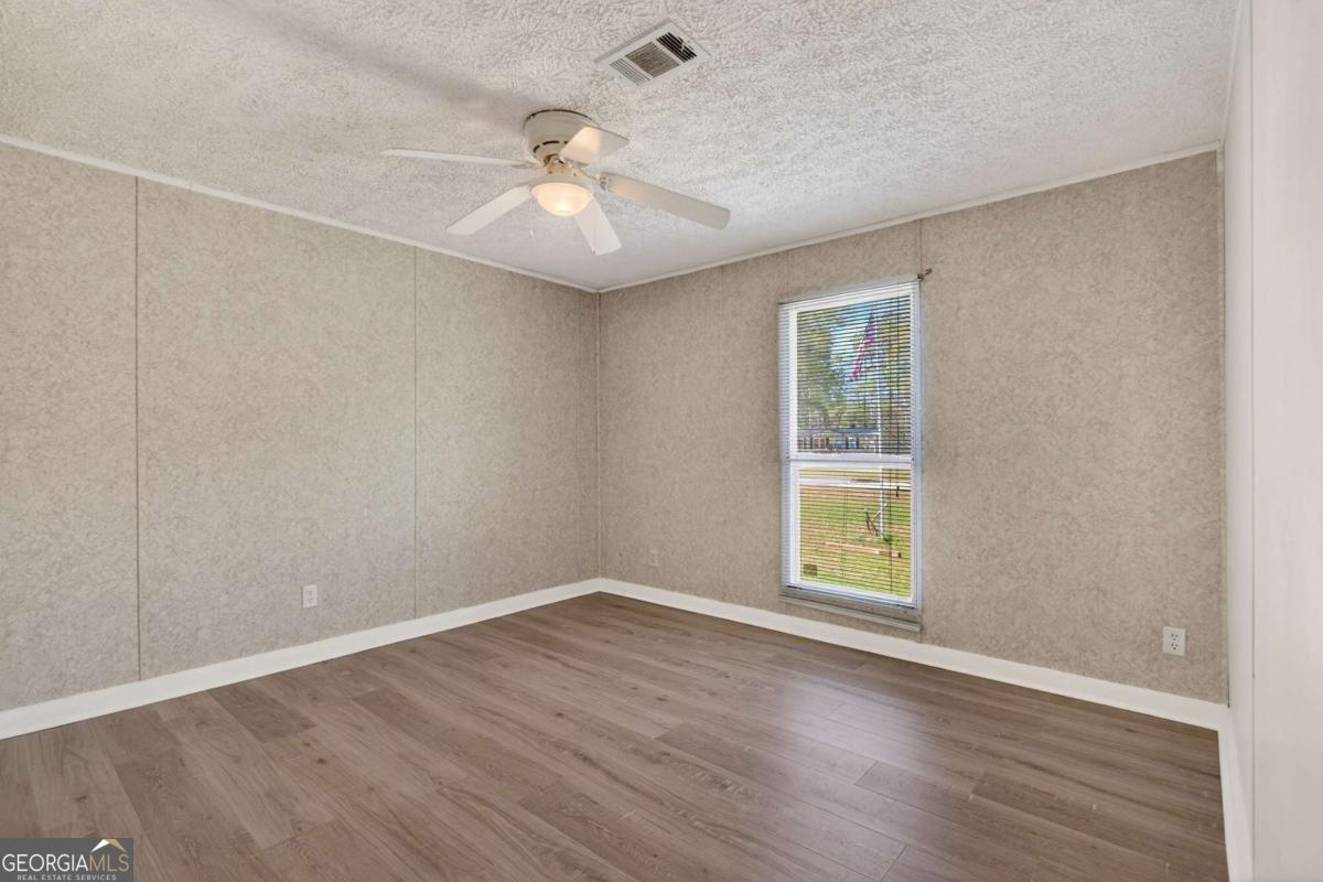 4156 Smiley Road Ludowici, GA 31316 - Photo 27 of 32 wooden floor in an empty room with a window