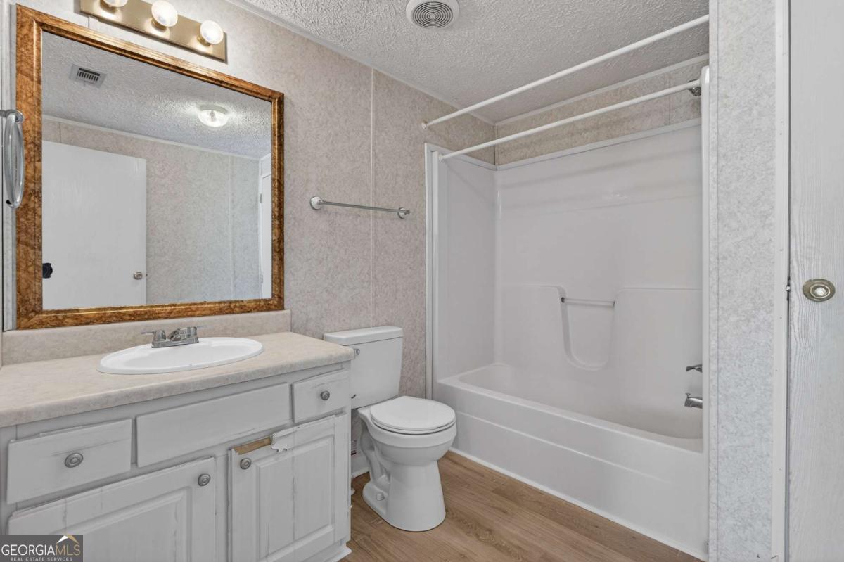 4156 Smiley Road Ludowici, GA 31316 - Photo 28 of 32 a bathroom with a bathtub shower sink vanity and toilet