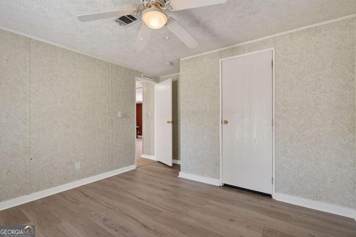 4156 Smiley Road Ludowici, GA 31316 - Photo 7 of 32 a view of an empty room and wooden floor
