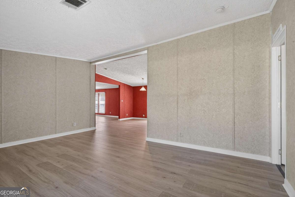 4156 Smiley Road Ludowici, GA 31316 - Photo 9 of 32 a view of an empty room with wooden floor