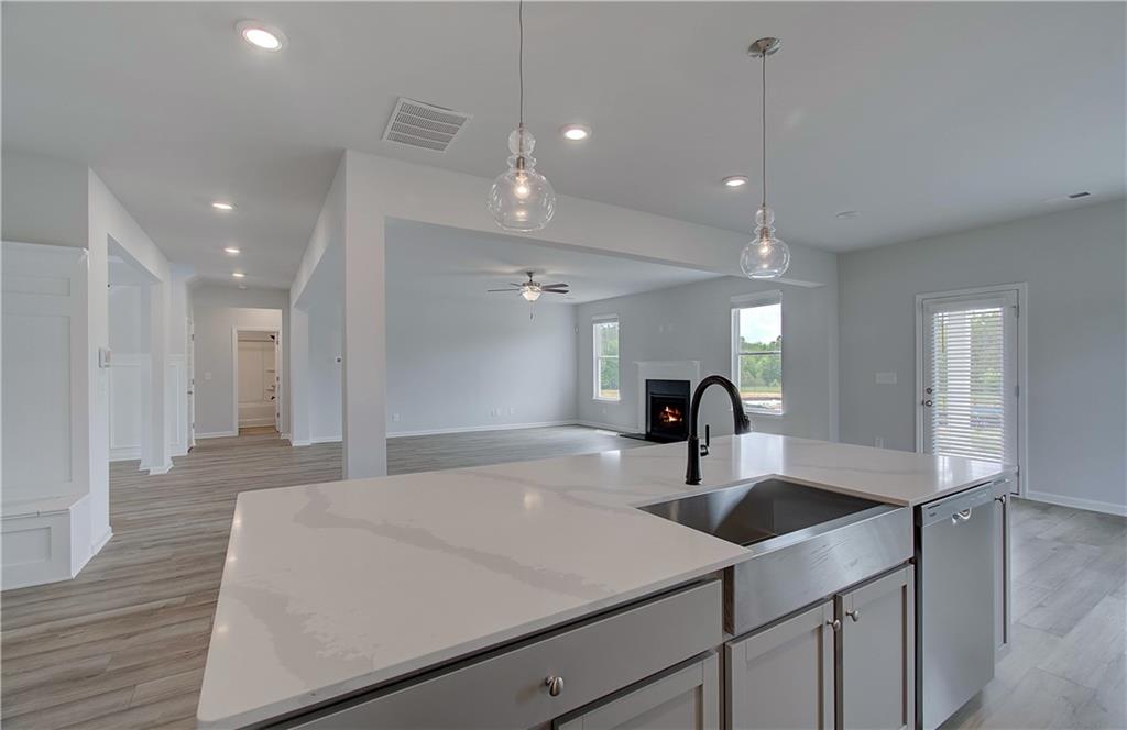 108 Felicity Pike Locust Grove, GA 30248 - Photo 19 of 37 a kitchen with kitchen island a sink stainless steel appliances and living room view