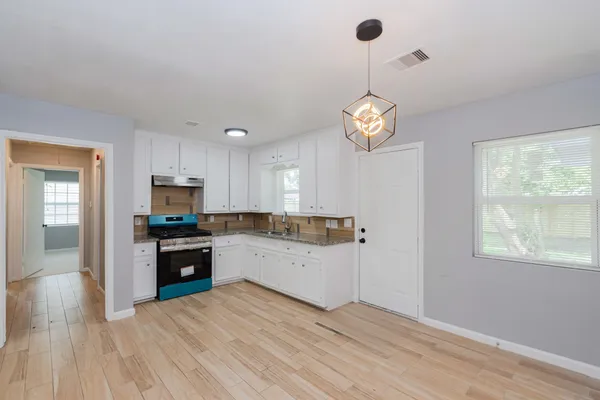 a kitchen with a refrigerator a stove top oven a sink dishwasher and a window