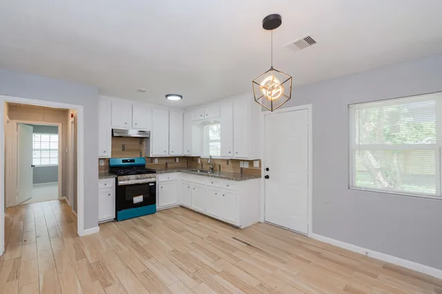 a kitchen with a refrigerator a stove top oven a sink dishwasher and a window