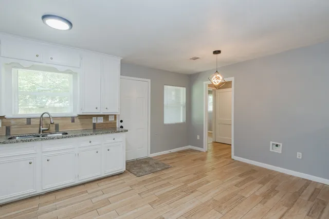 a view of a kitchen with a sink dishwasher a window and cabinets