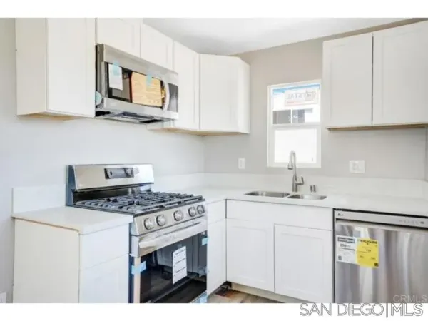a kitchen with stainless steel appliances granite countertop a stove a sink and a microwave