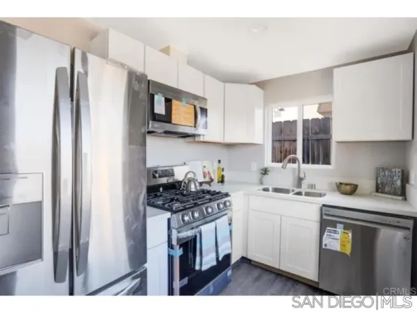 a kitchen with stainless steel appliances a sink stove refrigerator and cabinets