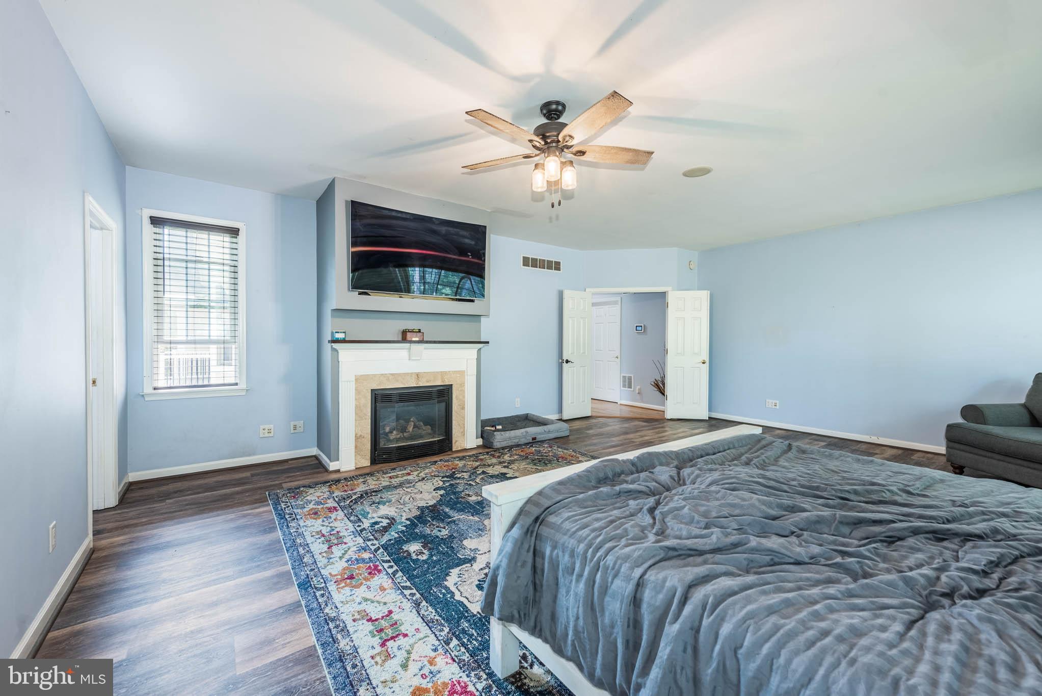 2623 Urey Road White Hall, MD 21161 - Photo 16 of 60 a spacious bedroom with a large bed and a fireplace