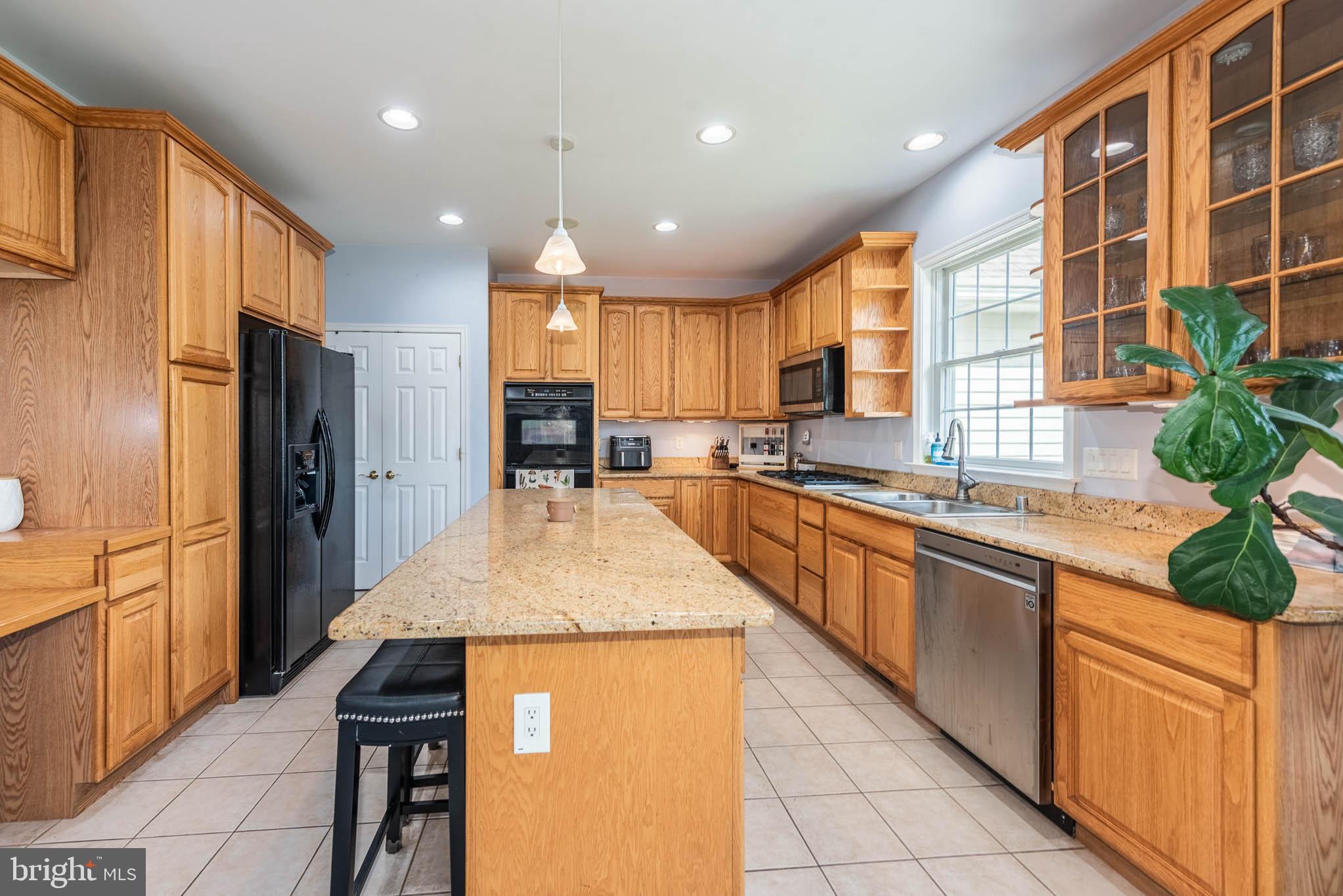 2623 Urey Road White Hall, MD 21161 - Photo 9 of 60 a kitchen with stainless steel appliances kitchen island granite countertop wooden cabinets a refrigerator and a sink
