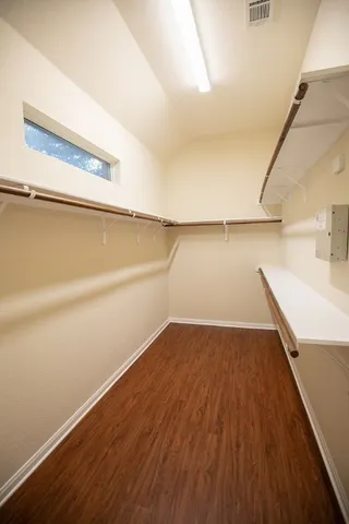 a view of an empty room with wooden floor