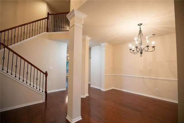 a view of a hallway with wooden floor and staircase