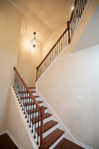 a view of staircase with railing and white walls