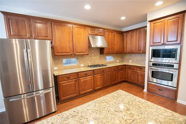 a kitchen with stainless steel appliances granite countertop a refrigerator sink and cabinets