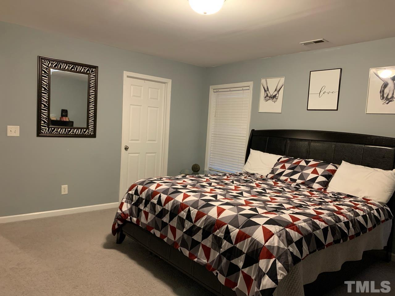 1422 Infinity Lane Raleigh, NC 27610 - Photo 14 of 16 a bedroom with a bed and painting on the wall