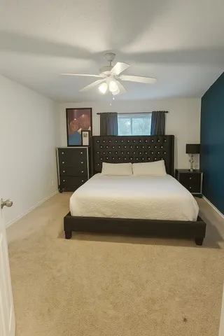 a large bed sitting in a room next to a lamp with kitchen and chandelier