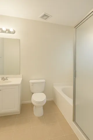 a white toilet sitting next to a white bath tub