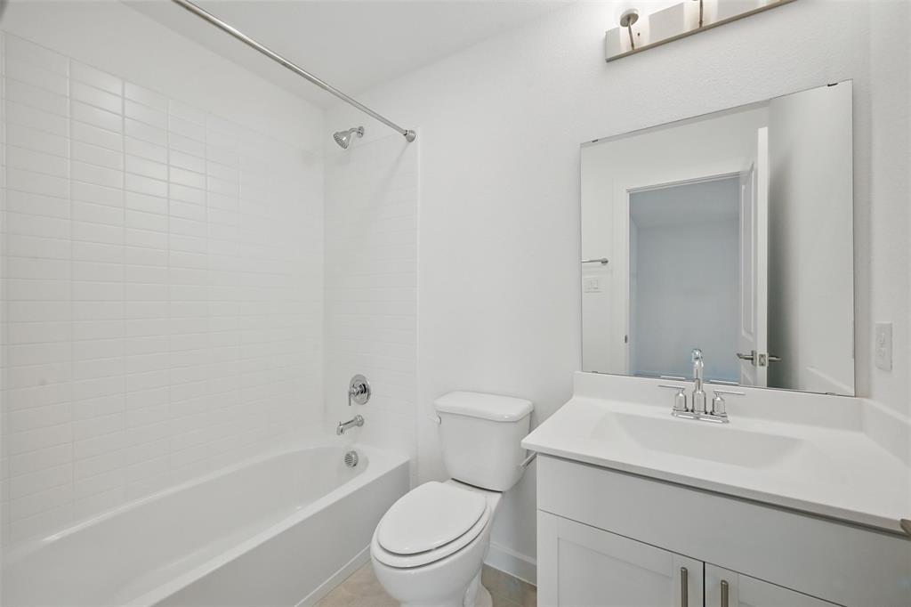 1413 Richardson Street Howe, TX 75459 - Photo 24 of 30 Bathroom with white subway tile shower surround, chrome fixtures, a white vanity with integrated sink, and a framed mirror