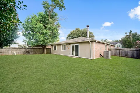 a view of a yard in front of a house with large trees