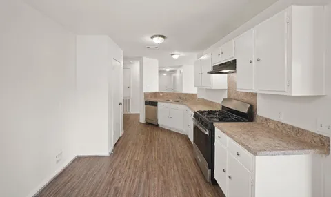 a kitchen with a sink a stove top oven and white kitchen