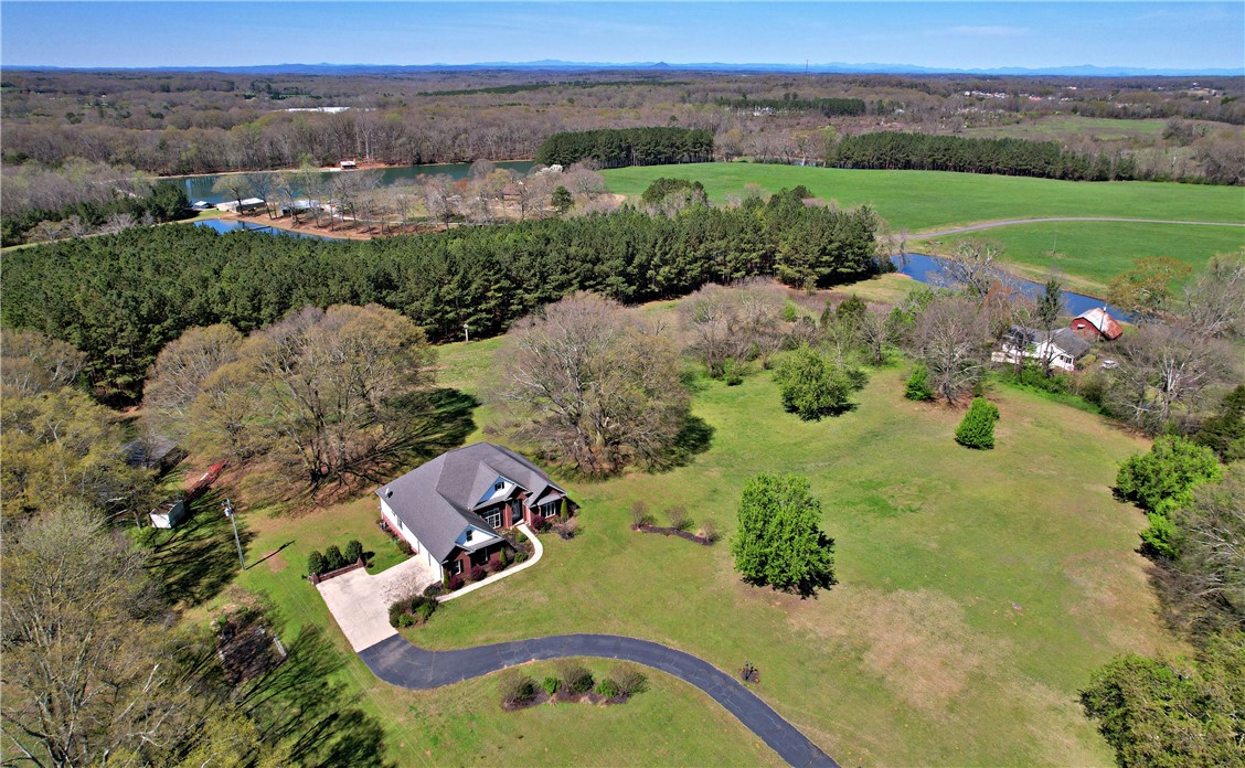 7893 Athens Road Carnesville, GA 30521 - Photo 44 of 50 This expansive estate offers a sprawling landscape with serene water features and verdant surroundings.