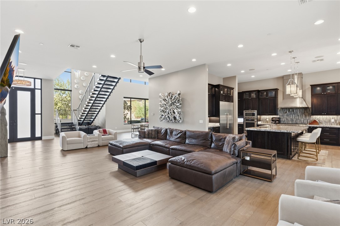 5 Crystal Tree Pass Henderson, NV 89052 - Photo 6 of 67 An open-concept great room offers high ceilings, light hardwood floors, and a well-appointed kitchen.