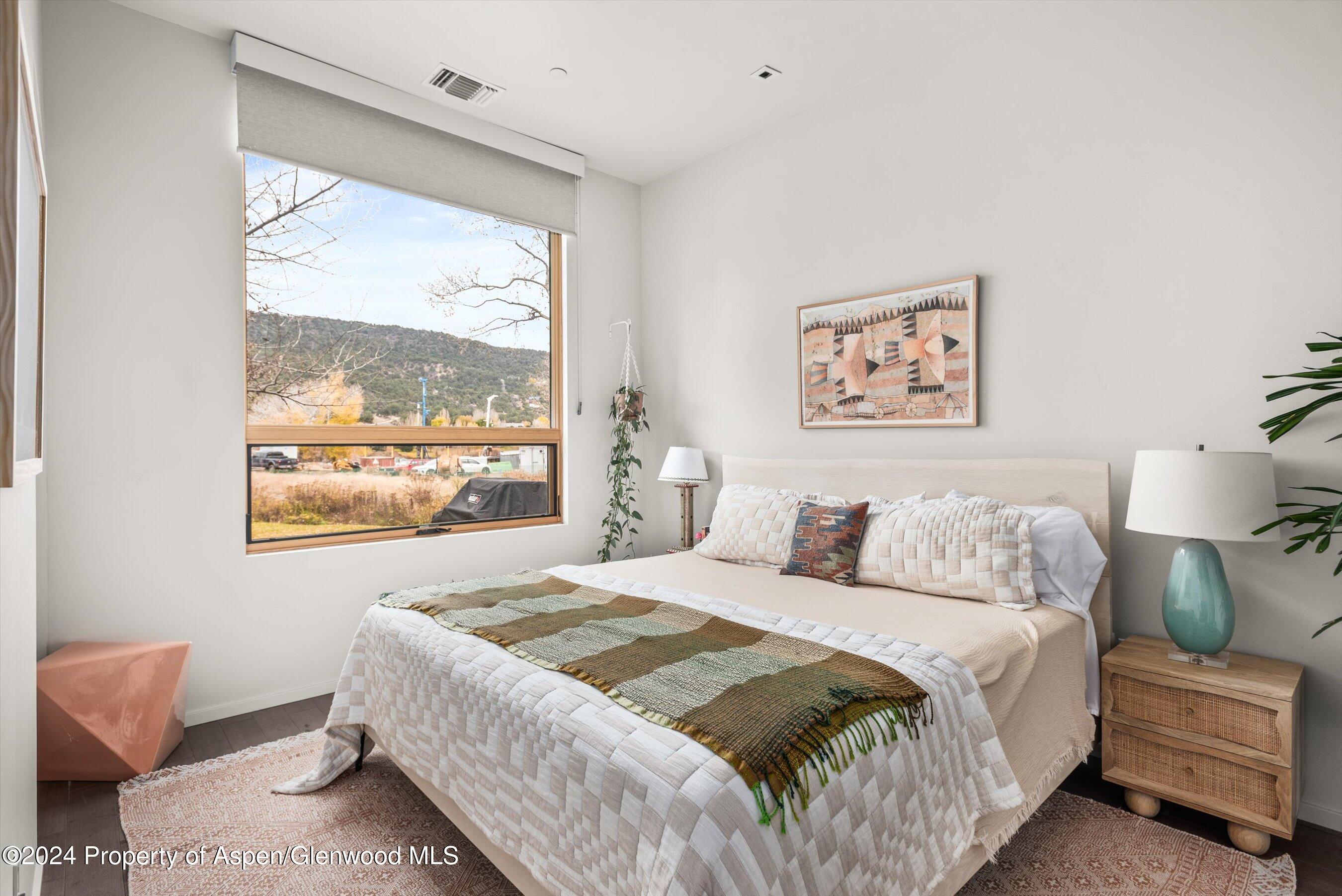 102 Evans Road, Unit 106 Basalt, CO 81621 - Photo 8 of 12 a bedroom with a bed and a large window