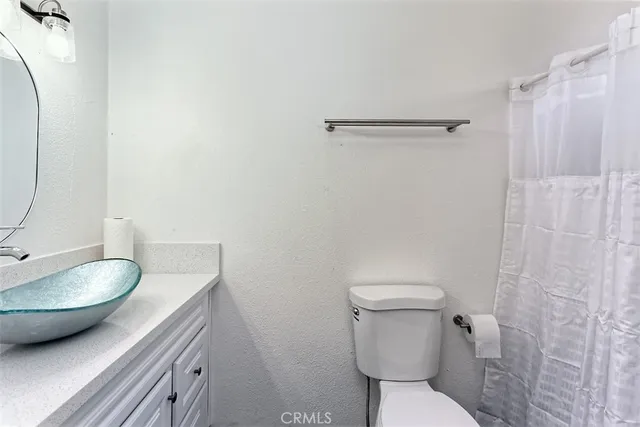 a bathroom with a granite countertop toilet and a sink