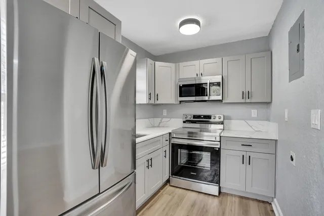 a kitchen with a refrigerator sink and stove top oven
