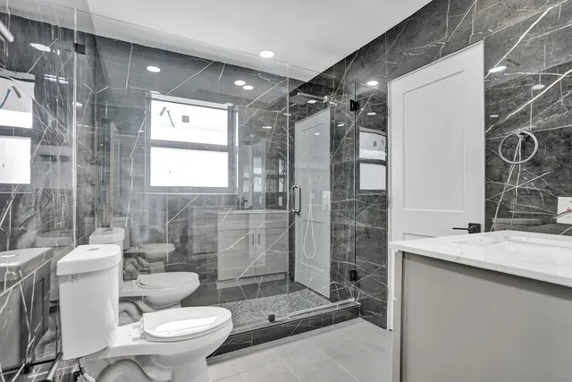 a bathroom with a sink toilet and shower