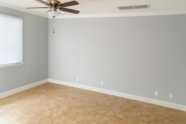 an empty room with a window and a fan