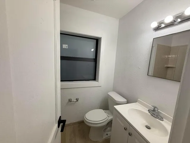 a bathroom with a toilet sink and mirror