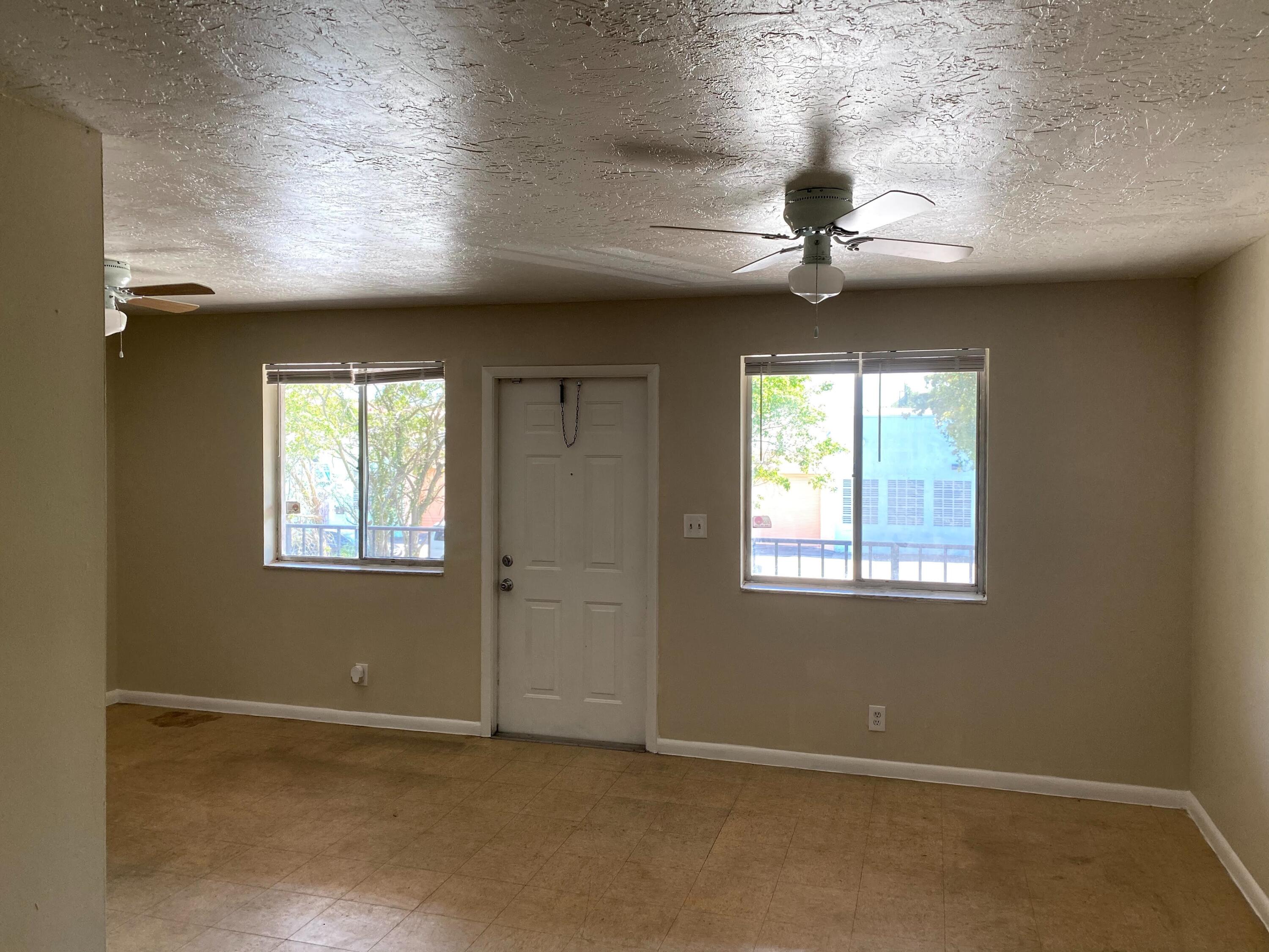 529 14th Street, Unit E West Palm Beach, FL 33401 - Photo 4 of 13 an empty room with windows and fan