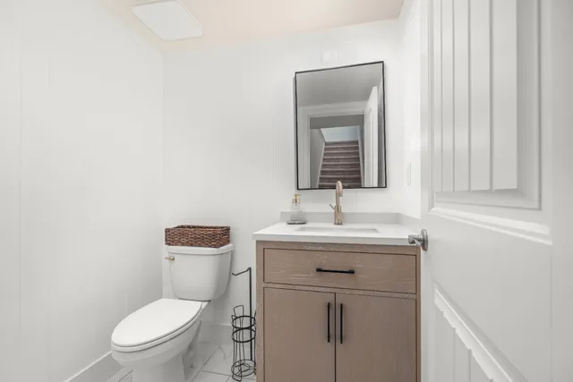 a bathroom with a toilet a sink and mirror