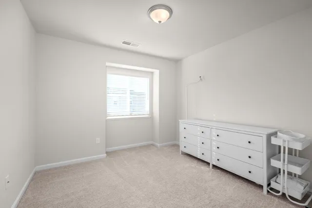 a room with a dresser and a window