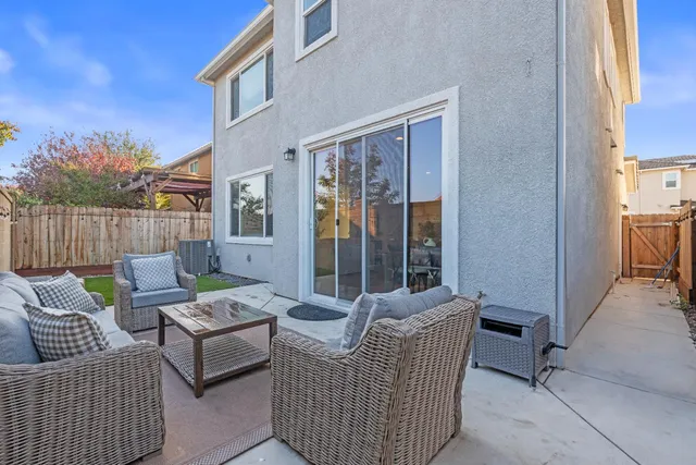 a view of a chair and table in backyard of the house
