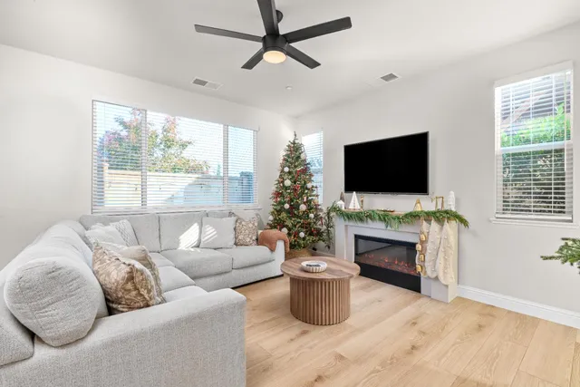 a living room with furniture a flat screen tv and a fireplace