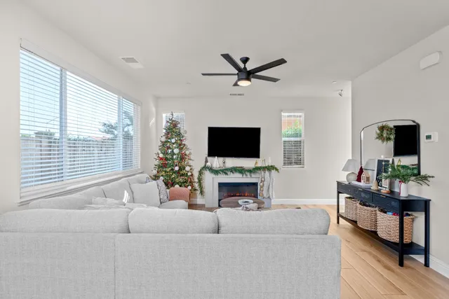 a living room with furniture a flat screen tv and a large window