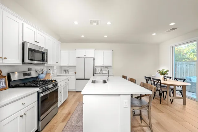 a kitchen with a table chairs stove and microwave