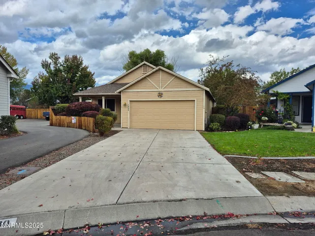 a view of a house with a yard and large tree